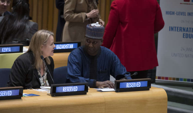 Zwei Representant*innen der Vereinten Nationen unterhalten sich im Plenarsaal