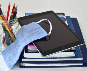 Maske, Tablet, Stifte und Schulbücher: Symbolbild fürs Homeschooling